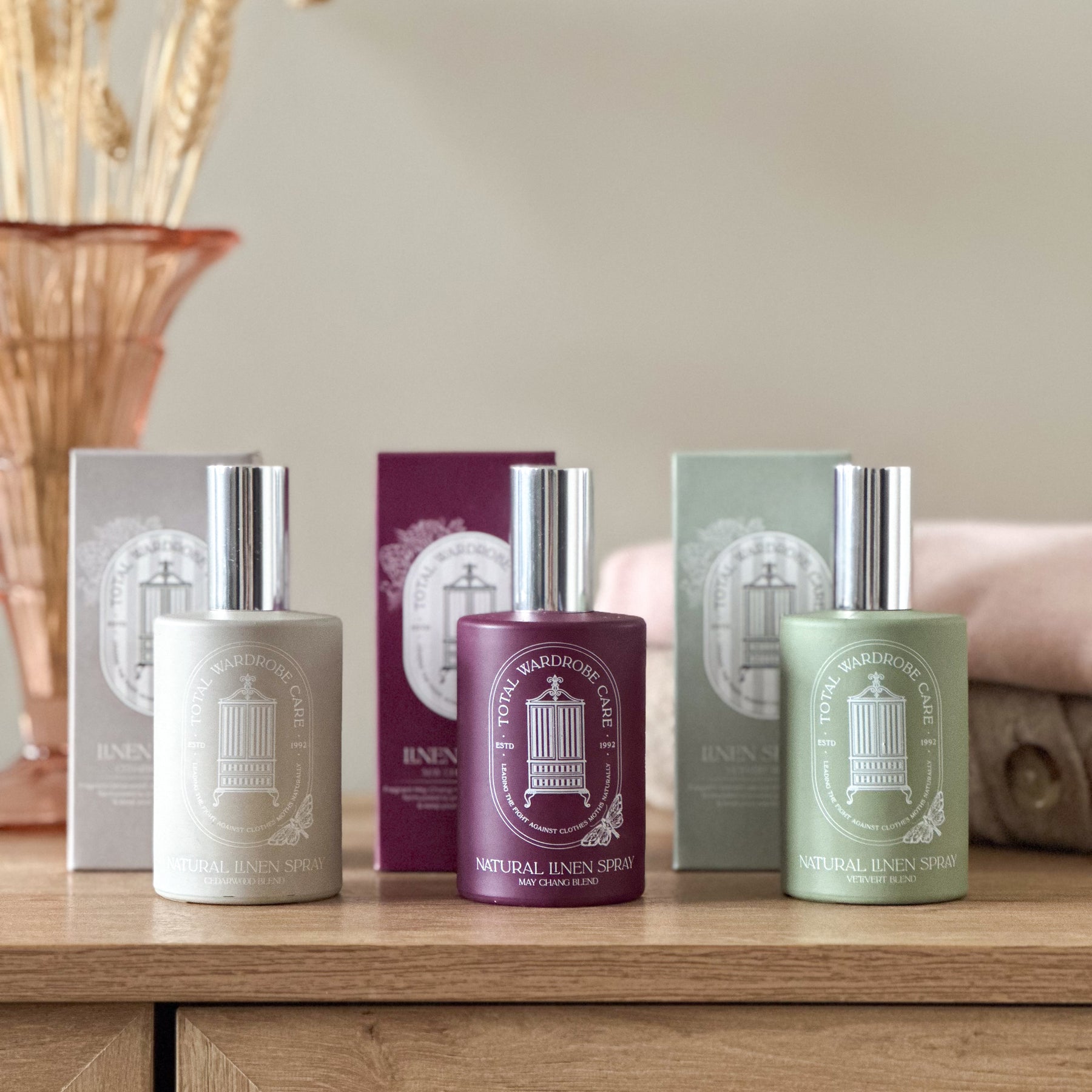 Our trio of anti-moth linen spray in separate colours on light wooden surface