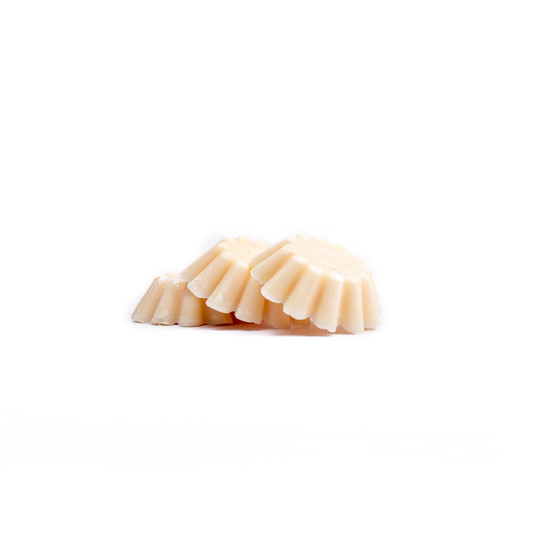 3 Cream coloured anti-moth wax melts on white background