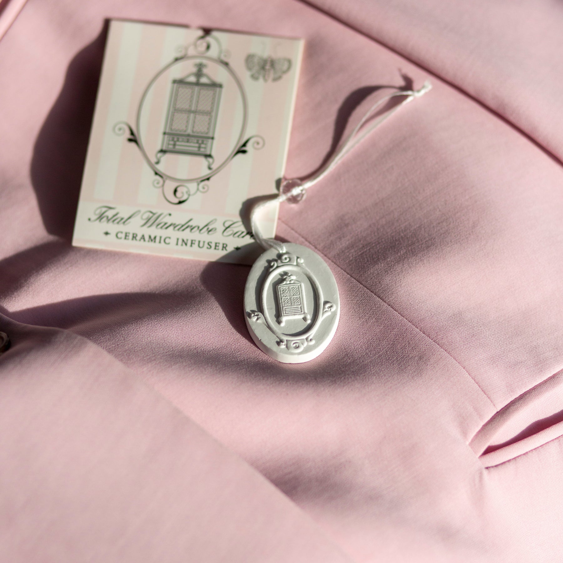 White ceramic hanger on top of pink blazer beside packaging