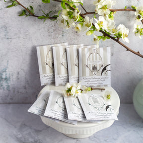Cedarwood drawer sachets on ceramic plate beneath white and green flowers