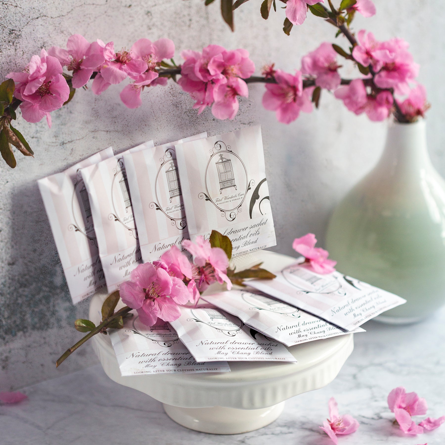 May chang drawer sachets lined on ceramic plate surrounded by pink flowers