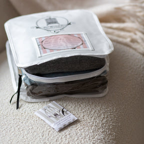 Cedarwood drawer sachet beside open knitwear and garment bag
