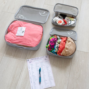 3 packing cubes open showing colourful holiday garments beside packing list