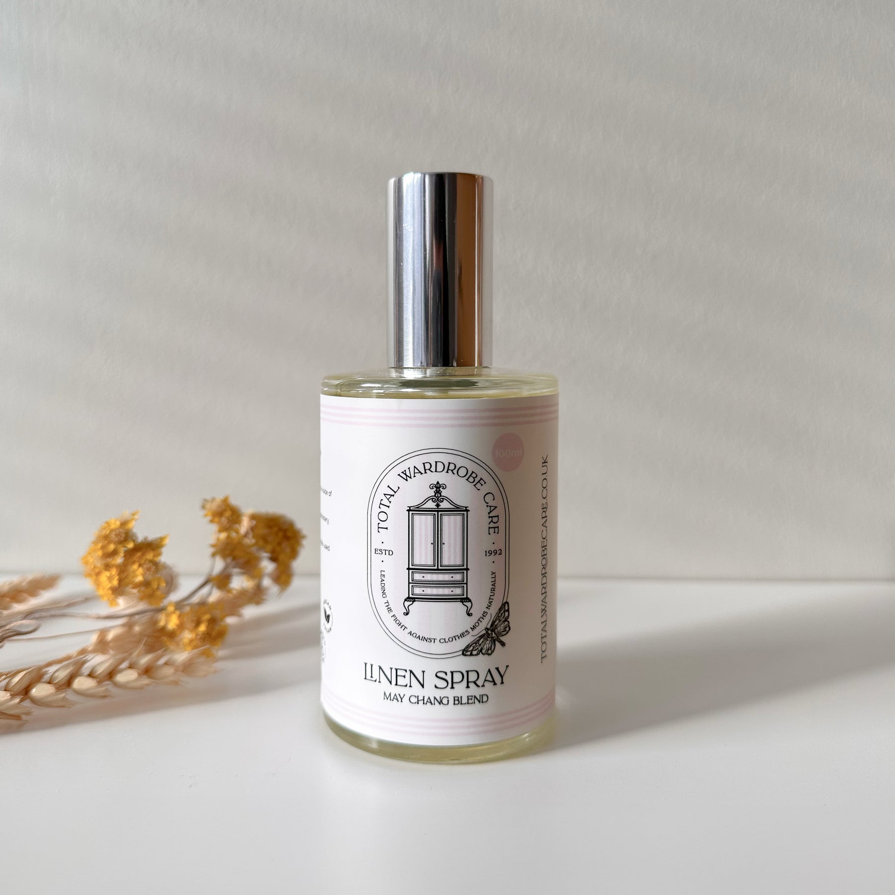 Dainty bottle of May Chang blend linen spray on white surface