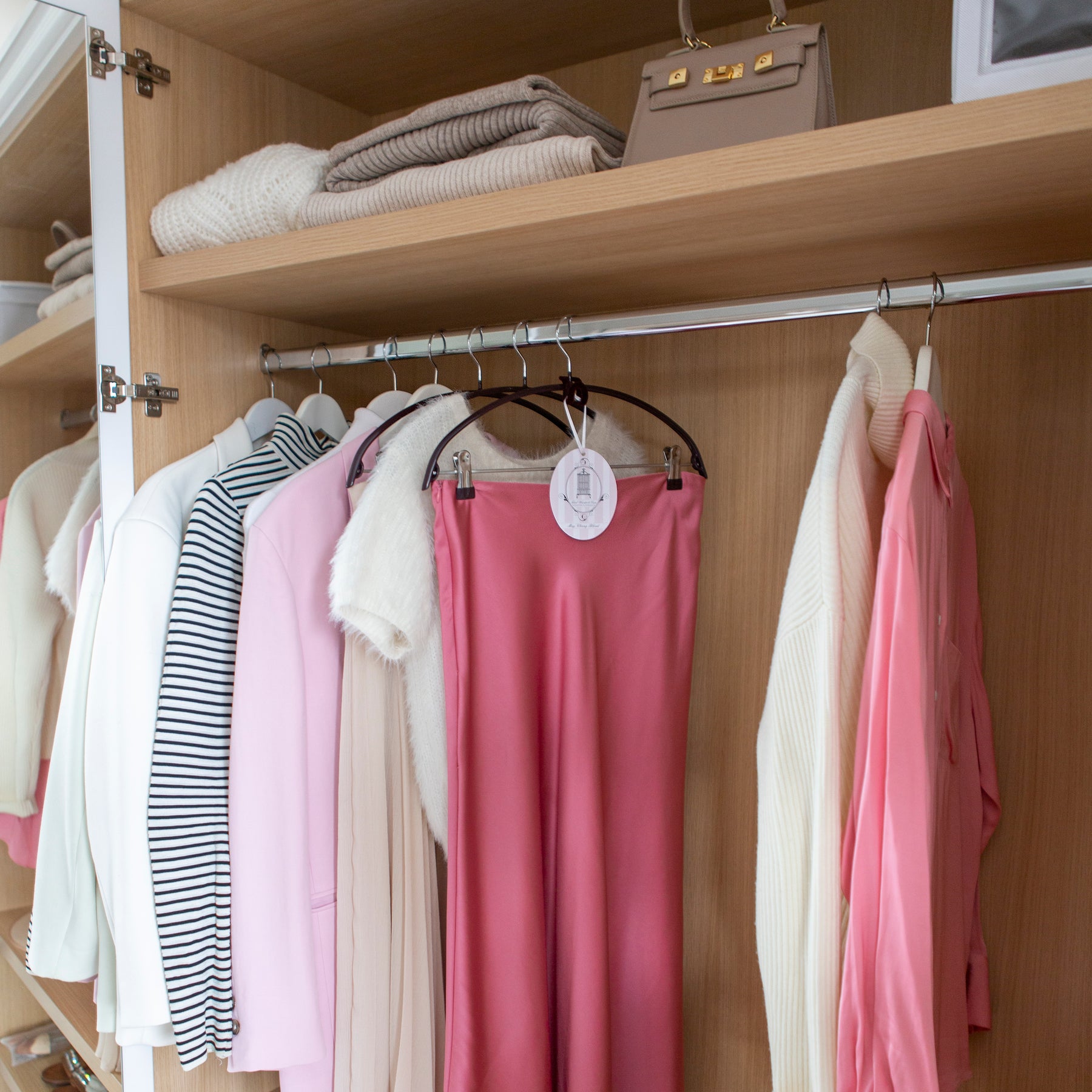 Scented hanging oval hanging in wardrobe among colourful garments 