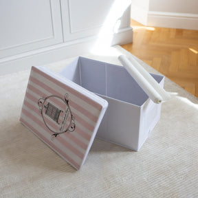Open storage box with lid leaning over side of box and roll of acid-free tissue paper over bottom corner with laminated flooring to reverse