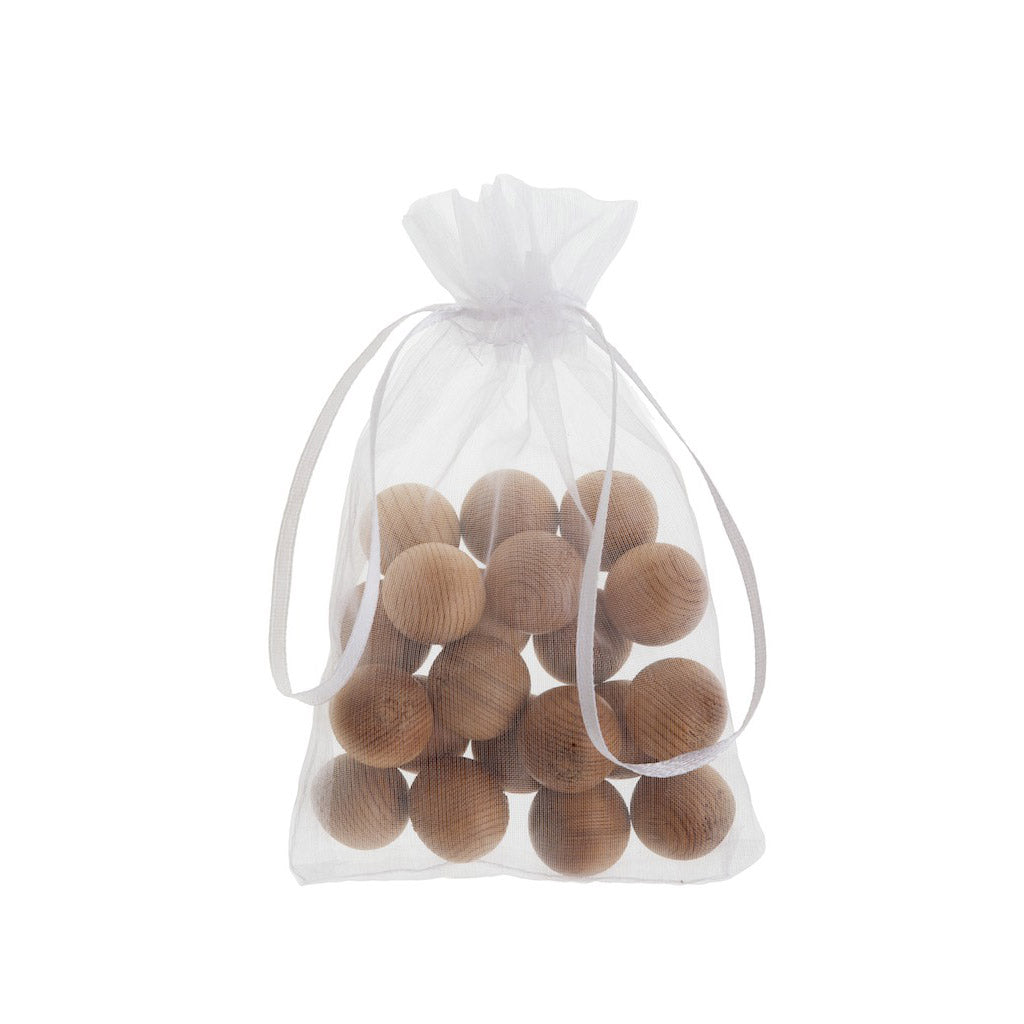 Sealed organza bag of canada red cedarwood balls on white background