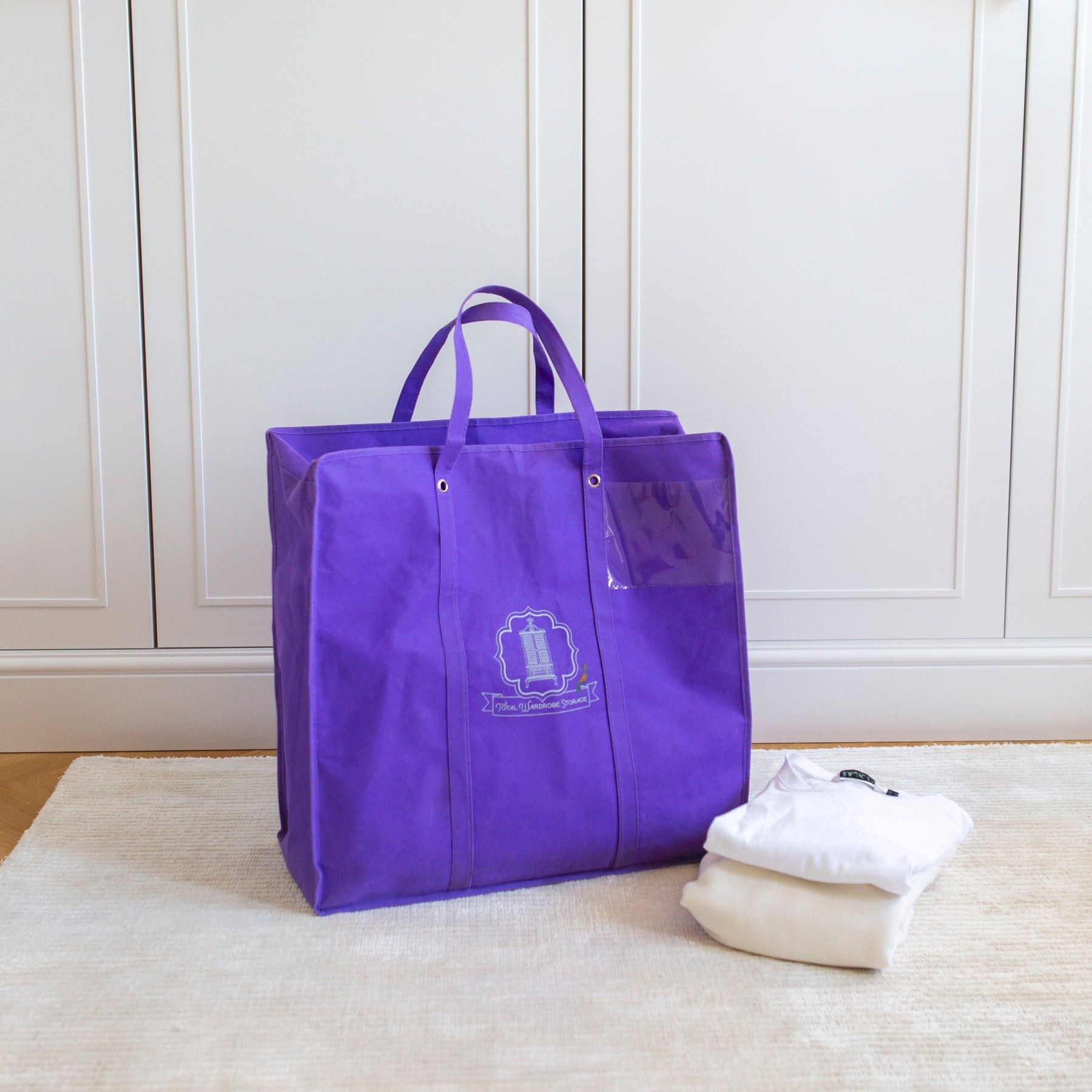Purple Total Wardrobe Care Laundry Bag beside two folded T-Shirts