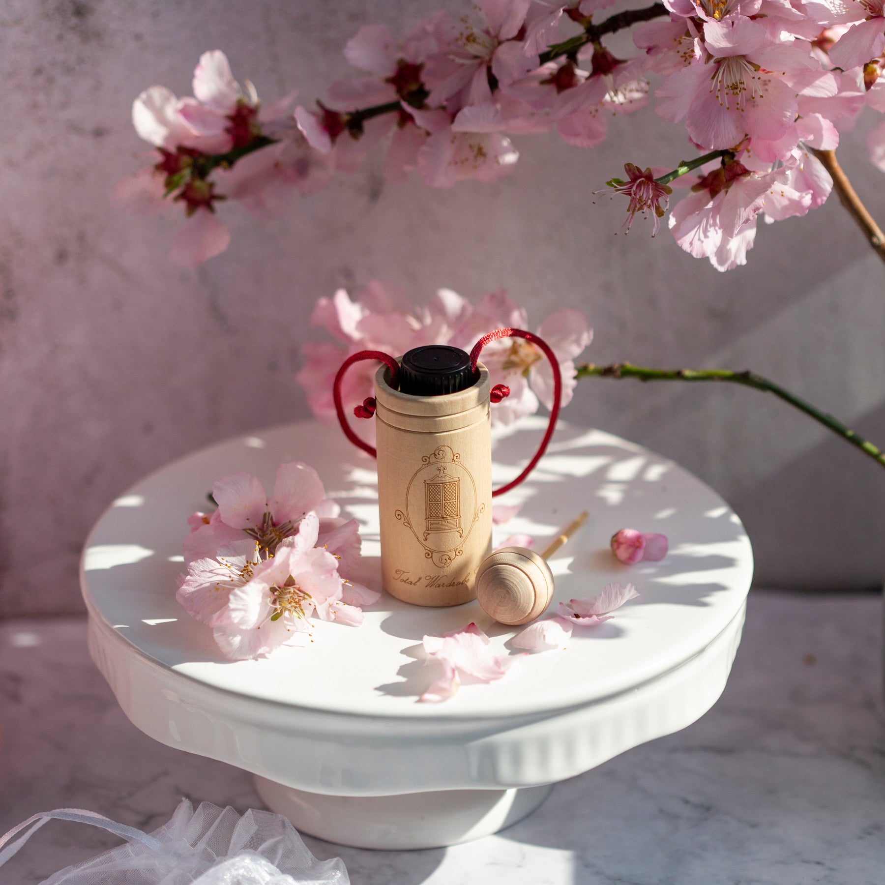 Wooden diffuser cup with essential oil inside surrounded by flowers