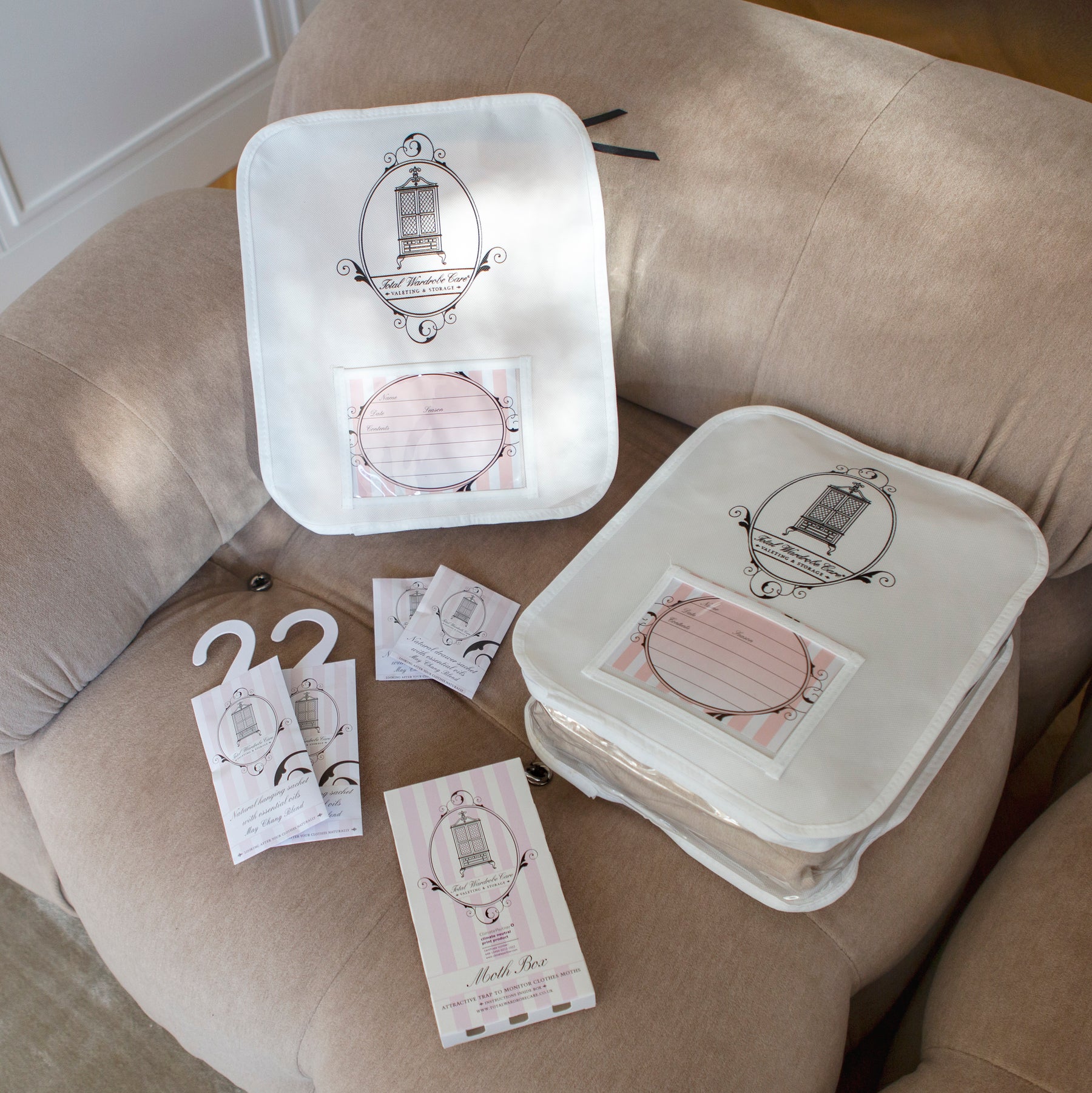 Anti-moth sachets, moth box and knitwear storage bags laid out on a pastel sofa