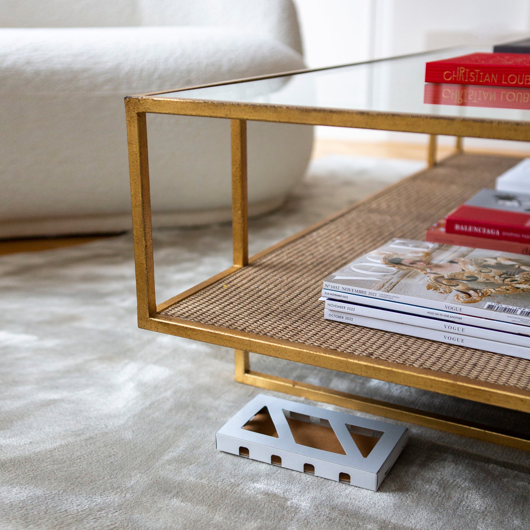 Moth Box placed underneath modern designed table with gold edging and Vogue magazines