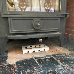 Small log burner with moth box placed underneath on the brickwork