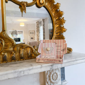 Moth Decoy stood inside packaging on marble mantlepiece beside luxury mirror